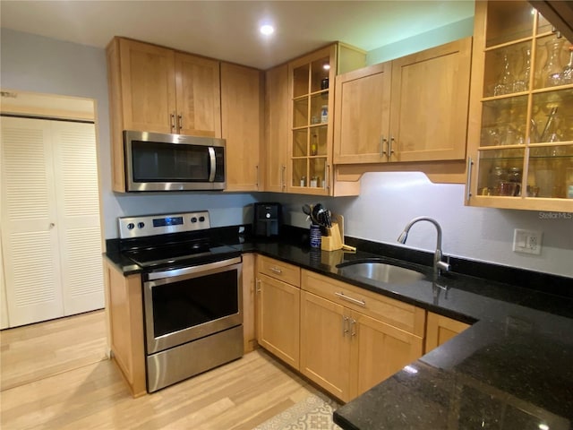 200 Maitland Ave Unit 232, Altamonte Springs, FL 32701 - kitchen with appliances with stainless steel finishes, dark stone countertops, light wood-type flooring, glass insert cabinets, and recessed lighting