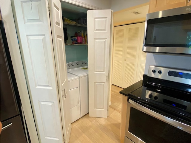 200 Maitland Ave Unit 232, Altamonte Springs, FL 32701 - kitchen featuring stainless steel appliances, washing machine and clothes dryer, and light wood-style flooring
