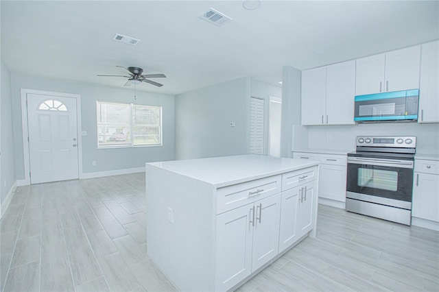 2501 Stratford Dr, Cocoa, FL 32926 - kitchen featuring stainless steel appliances, a ceiling fan, light countertops, and white cabinetry
