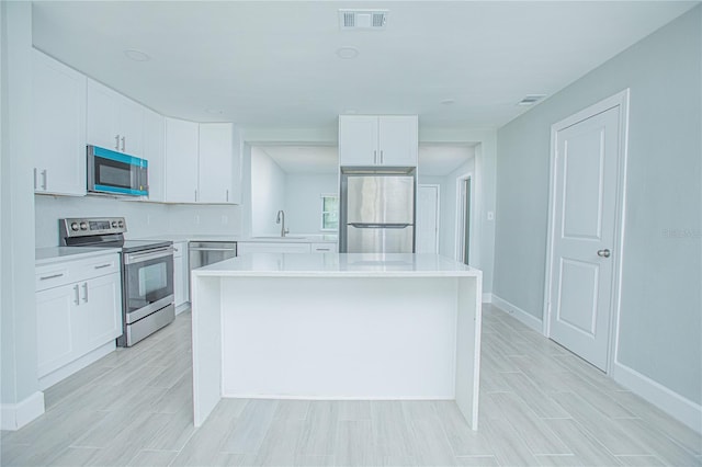 2501 Stratford Dr, Cocoa, FL 32926 - kitchen with appliances with stainless steel finishes, light countertops, a sink, and white cabinets
