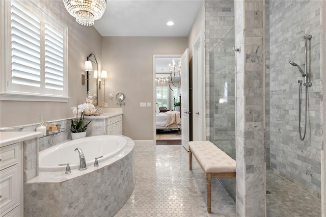ensuite bathroom featuring a bath, a walk in shower, vanity, a notable chandelier, and ensuite bath