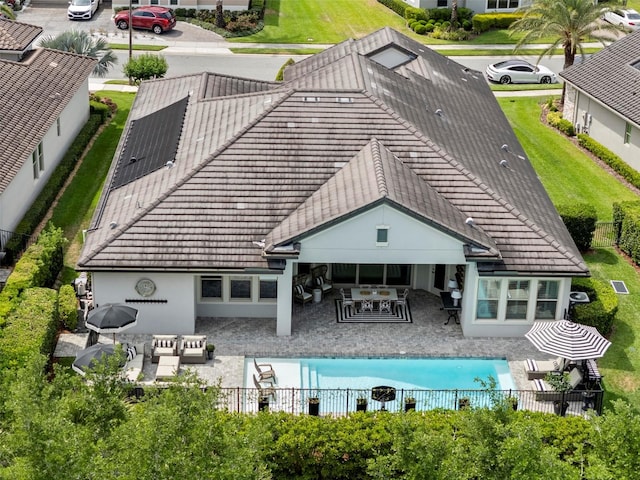 back of house featuring fence, stucco siding, an outdoor living space, a patio area, and a tiled roof