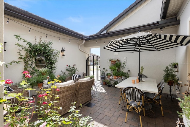 view of patio with a gate, outdoor dining space, and an outdoor living space