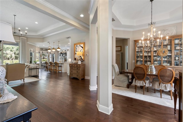dining room featuring dark wood-style flooring, a raised ceiling, a chandelier, baseboards, and ornamental molding