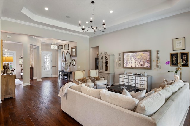 living room with crown molding, a raised ceiling, a chandelier, baseboards, and dark wood-style floors