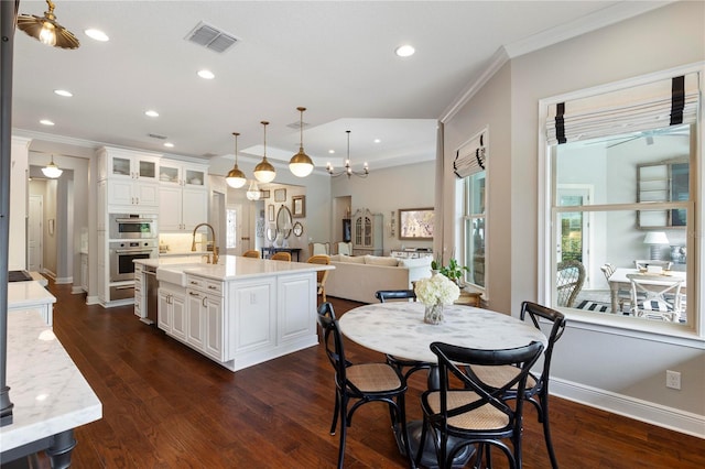 kitchen with visible vents, ornamental molding, a sink, and white cabinets