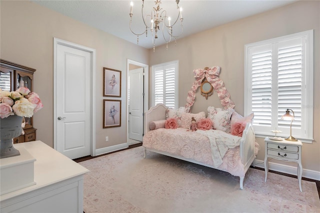 bedroom with baseboards and a chandelier