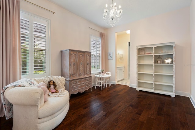 sitting room featuring an inviting chandelier, baseboards, and hardwood / wood-style flooring