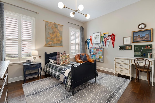 bedroom with an inviting chandelier, wood finished floors, and multiple windows