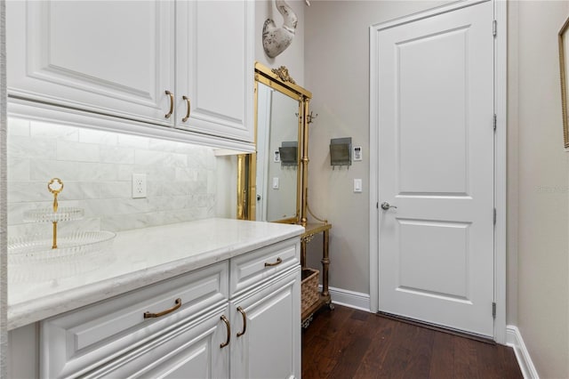 interior space featuring baseboards and dark wood finished floors