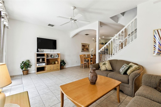 1180 S Beach Cir, Kissimmee, FL 34746 - living room featuring light tile patterned flooring, arched walkways, a ceiling fan, stairway, and baseboards
