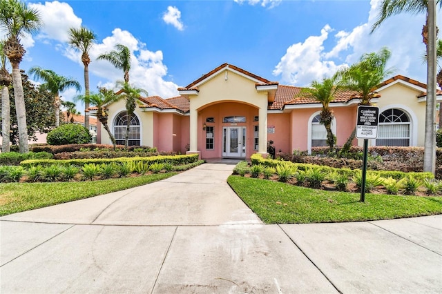 1180 S Beach Cir, Kissimmee, FL 34746 - mediterranean / spanish-style home with french doors, a tiled roof, and stucco siding
