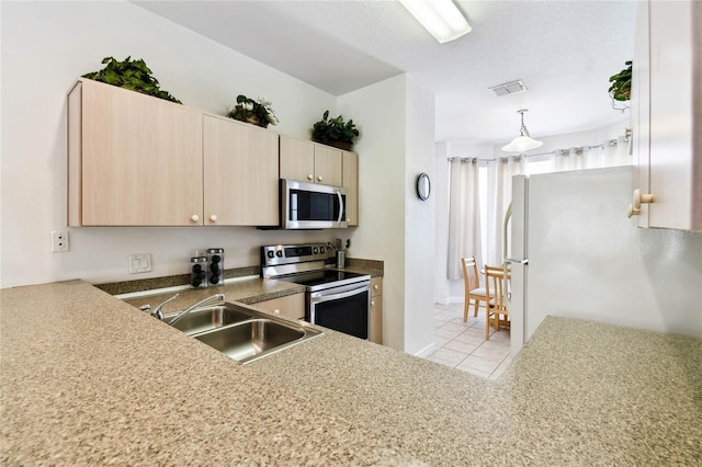 1180 S Beach Cir, Kissimmee, FL 34746 - kitchen featuring appliances with stainless steel finishes, a sink, light brown cabinets, light tile patterned floors, and pendant lighting