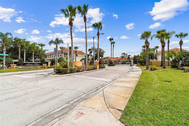 1180 S Beach Cir, Kissimmee, FL 34746 - view of asphalt street with curbs, street lights, a gated entry, and sidewalks