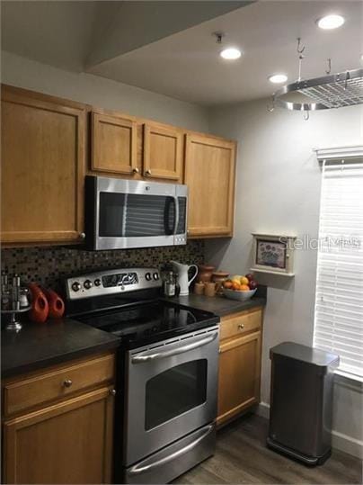 8973 Lee Vista Blvd Unit 2308, Orlando, FL 32829 - kitchen with dark countertops, stainless steel appliances, tasteful backsplash, and dark wood-type flooring