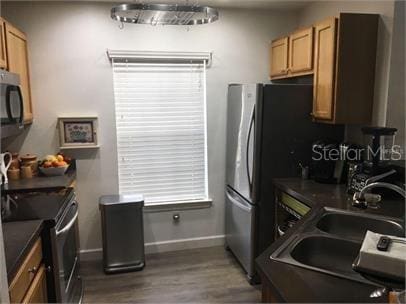 8973 Lee Vista Blvd Unit 2308, Orlando, FL 32829 - kitchen featuring dark countertops, wood finished floors, baseboards, and a sink