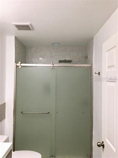 8973 Lee Vista Blvd Unit 2308, Orlando, FL 32829 - bathroom with toilet, visible vents, vanity, and a stall shower