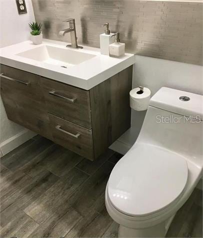 8973 Lee Vista Blvd Unit 2308, Orlando, FL 32829 - bathroom featuring toilet, vanity, and wood finished floors