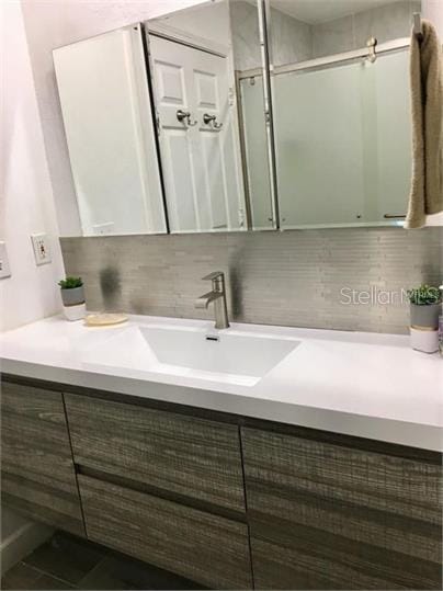 8973 Lee Vista Blvd Unit 2308, Orlando, FL 32829 - bathroom with a stall shower, vanity, and backsplash