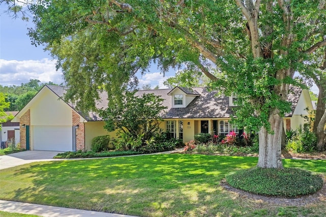 new england style home with an attached garage, driveway, a front lawn, and brick siding