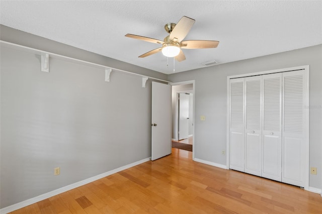 unfurnished bedroom featuring baseboards, light wood finished floors, and visible vents
