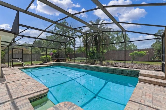 view of pool with glass enclosure, a fenced in pool, a fenced backyard, and a patio area
