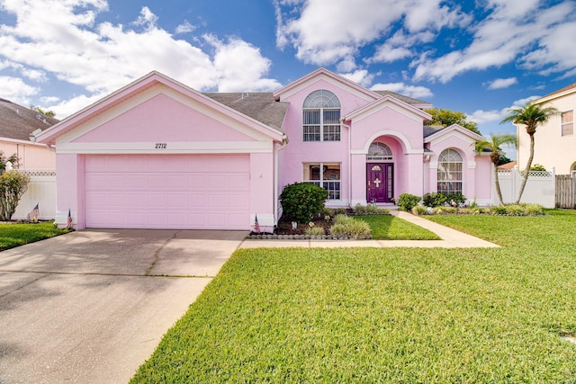 2712 Rolling Broak Dr, Orlando, FL 32837 - mediterranean / spanish-style house with fence, an attached garage, a front lawn, stucco siding, and concrete driveway