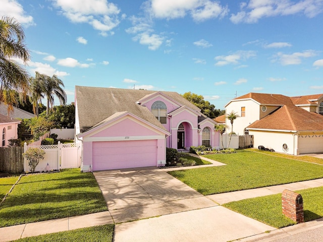 2712 Rolling Broak Dr, Orlando, FL 32837 - view of front of home featuring a garage, a front lawn, fence, and concrete driveway