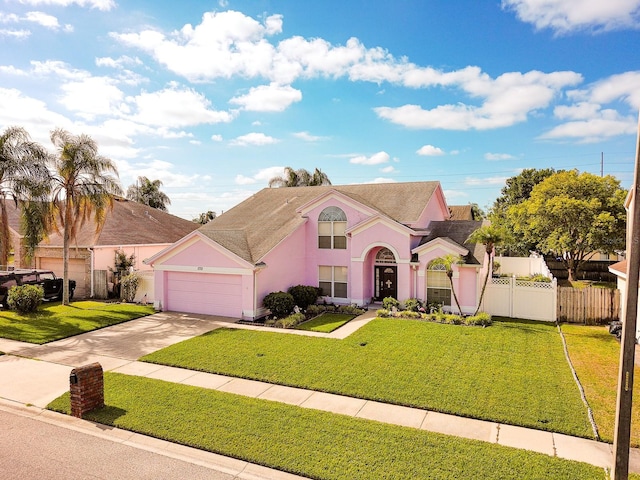 2712 Rolling Broak Dr, Orlando, FL 32837 - view of front of property featuring fence, a front lawn, a garage, stucco siding, and concrete driveway