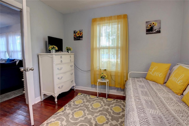 bedroom with wood-type flooring, baseboards, and multiple windows