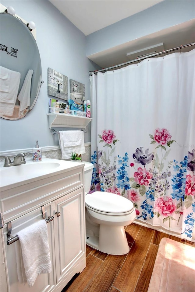 bathroom featuring vanity, a shower with curtain, toilet, and wood finished floors