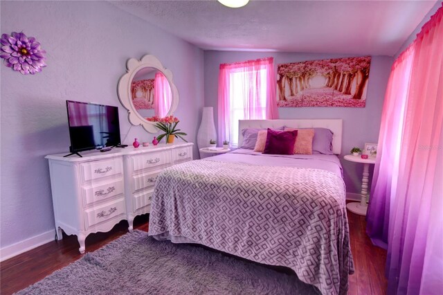 bedroom featuring dark wood-type flooring and baseboards