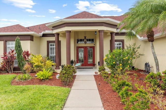 2818 Mossy Timber Trl, Valrico, FL 33596 - view of exterior entry featuring french doors, stucco siding, roof with shingles, and a yard