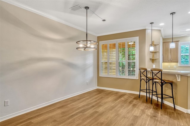 dining area with an inviting chandelier, visible vents, baseboards, light wood-style floors, and ornamental molding
