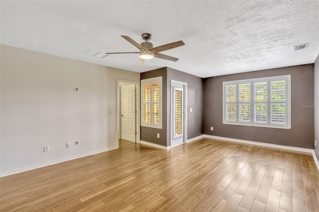 spare room with baseboards, a ceiling fan, and visible vents