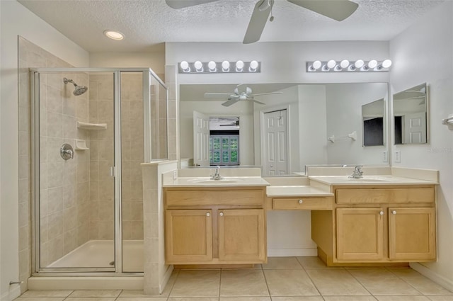 bathroom featuring a ceiling fan, a textured ceiling, and a stall shower