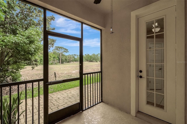 unfurnished sunroom with ceiling fan