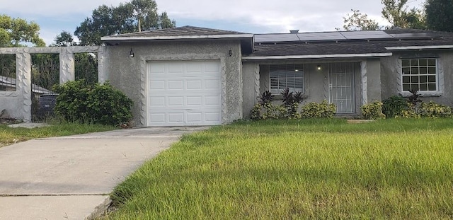 ranch-style house with driveway, roof with shingles, roof mounted solar panels, an attached garage, and stucco siding
