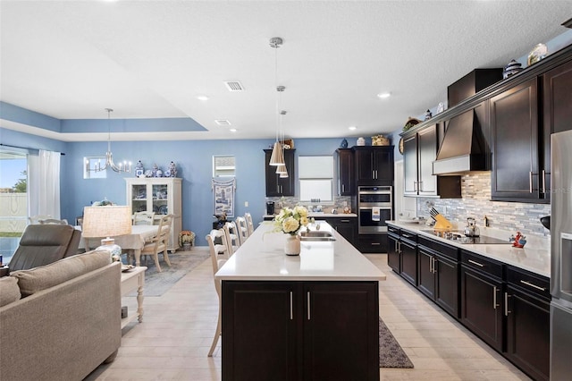 kitchen with backsplash, a chandelier, visible vents, black electric cooktop, and open floor plan