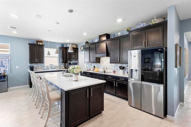 kitchen featuring backsplash, visible vents, light countertops, baseboards, and stainless steel appliances
