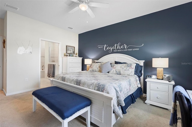 bedroom with visible vents, ensuite bathroom, a ceiling fan, and light colored carpet