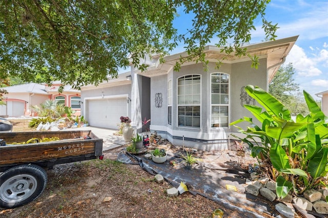 view of front facade featuring a garage, stucco siding, and concrete driveway