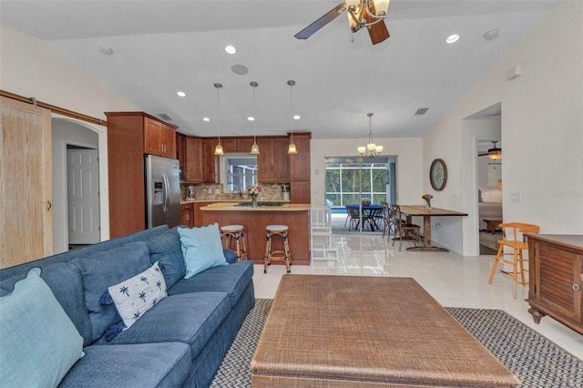 living room with ceiling fan, lofted ceiling, recessed lighting, and a chandelier