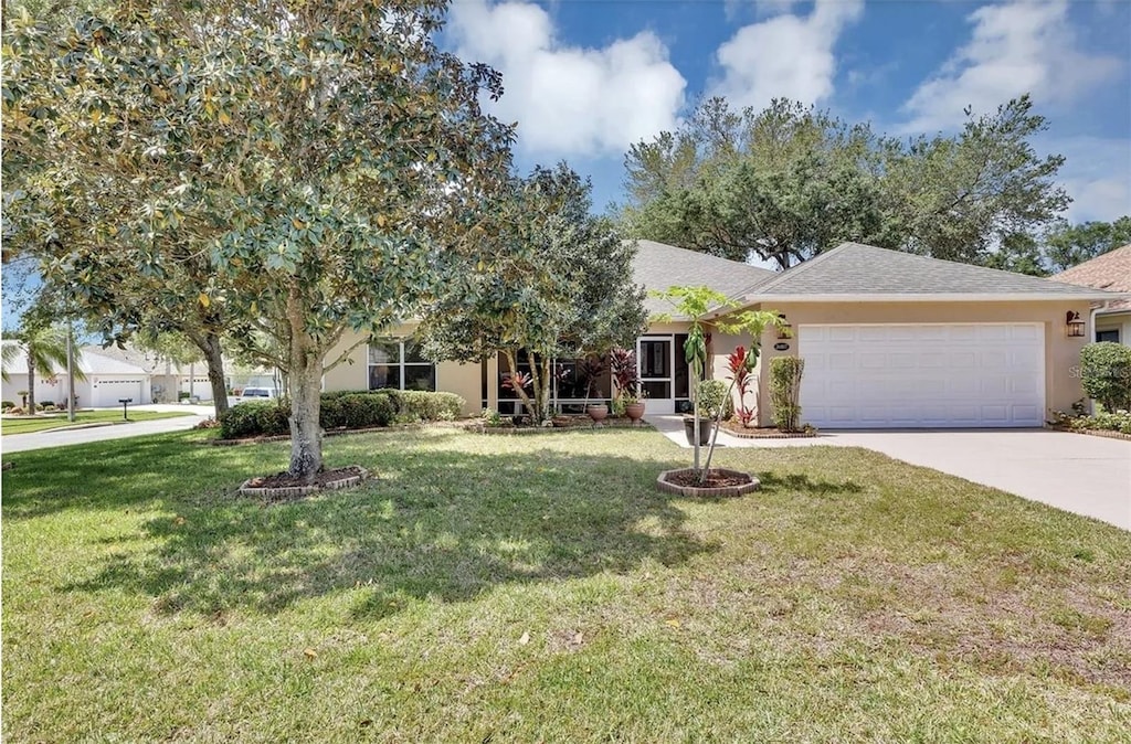 view of front of property featuring driveway, a garage, a front lawn, a shingled roof, and stucco siding