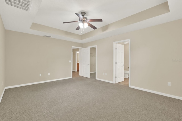 26807 Bull Run, Leesburg, FL 34748 - unfurnished bedroom with a raised ceiling, carpet flooring, baseboards, a spacious closet, and ensuite bath