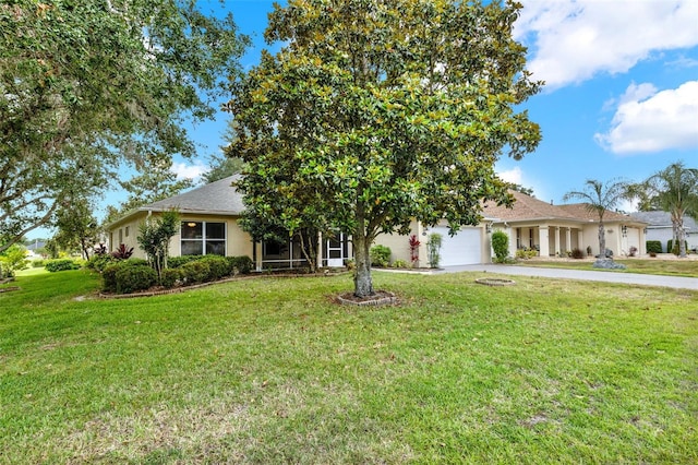 26807 Bull Run, Leesburg, FL 34748 - view of front of home featuring driveway, a garage, a front lawn, and stucco siding