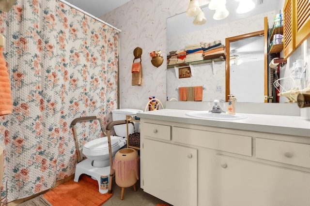 bathroom featuring a shower with curtain, vanity, tile patterned floors, toilet, and wallpapered walls