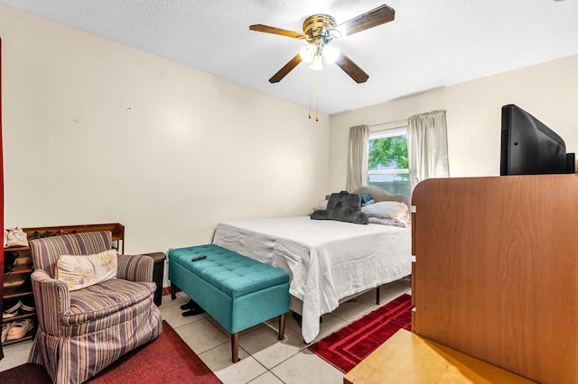 bedroom featuring a textured ceiling, ceiling fan, and tile patterned floors