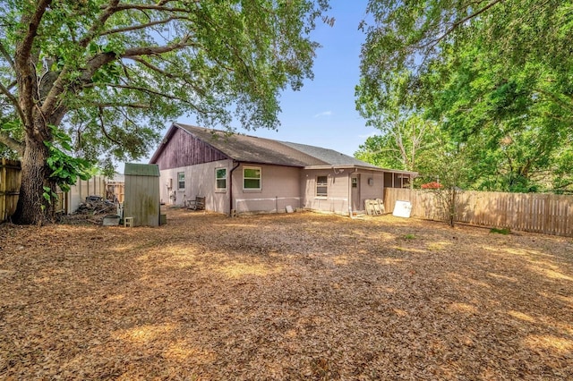 rear view of property with a shingled roof and a fenced backyard