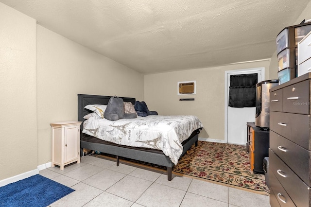 bedroom with baseboards, a wall mounted AC, and a textured ceiling